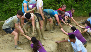 Cranleigh Lower VI students getting muddy in team-building exercise