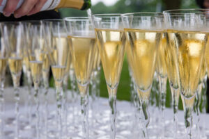 Photo of row of glasses being filled with champagne