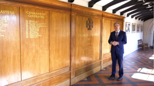 Cranleigh School Headmaster, Martin Reader, speakinf in front of honours boards